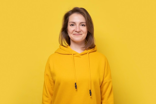 Young pretty caucasian woman smiling at camera Studio shot on yellow wall