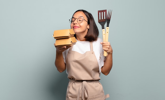 写真 若いかわいいシェフの女性。ファーストフードのコンセプト