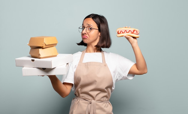 Foto giovane donna graziosa del cuoco unico. concetto di fast food