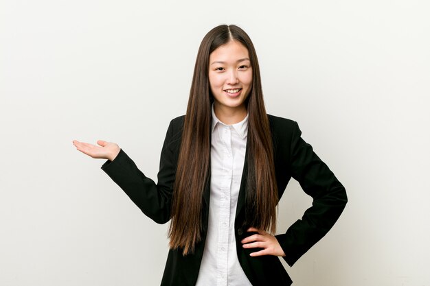 Young pretty chinese business woman holding hand on waist