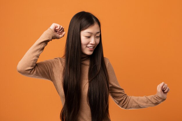 Young pretty chinese woman dancing and having fun.