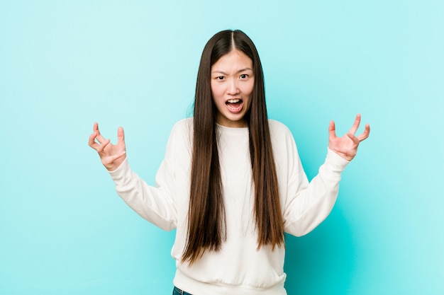 Young pretty chinese woman screaming with rage.