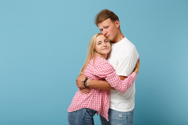 Young pretty couple two friends guy girl in white pink empty blank design t-shirts posing 