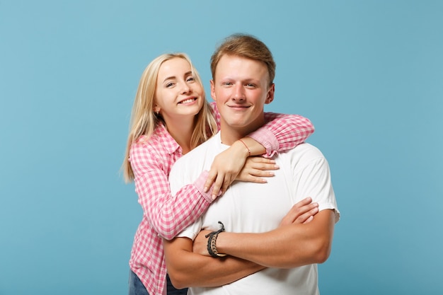 Young pretty couple two friends guy girl in white pink empty blank design t-shirts posing 