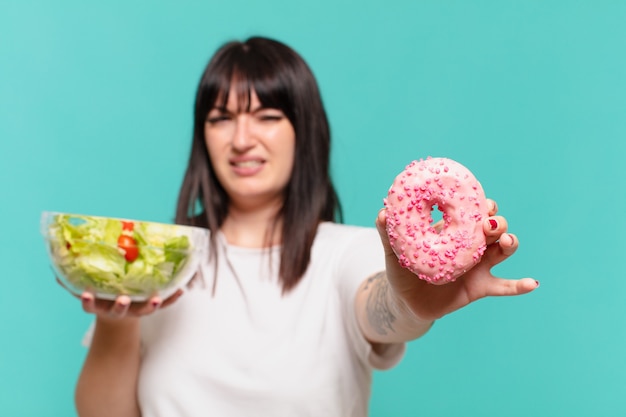 Young pretty curvy woman doubting with uncertain expression