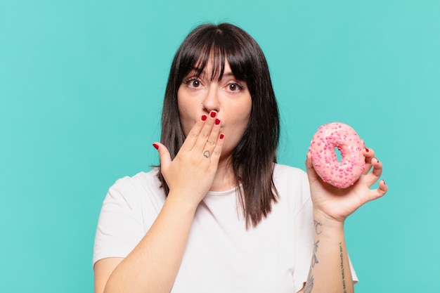 Photo young pretty curvy woman scared expression and holding a donut