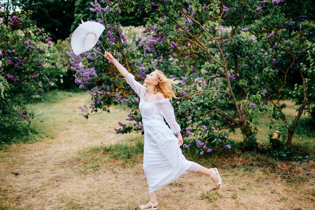 Young pretty european girl in white dress portrait in park outdoor