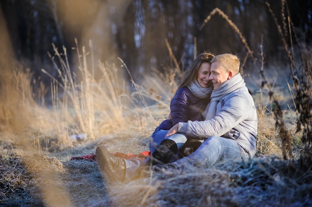 Молодая красивая мода чувственная пара в любви, сидя в зимнем холодном поле