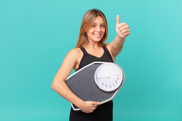 Young pretty fitness woman feeling proud,smiling positively with thumbs up