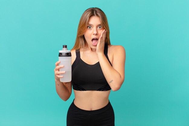 Young pretty fitness woman feeling shocked and scared