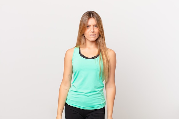 Young pretty fitness woman looking puzzled and confused