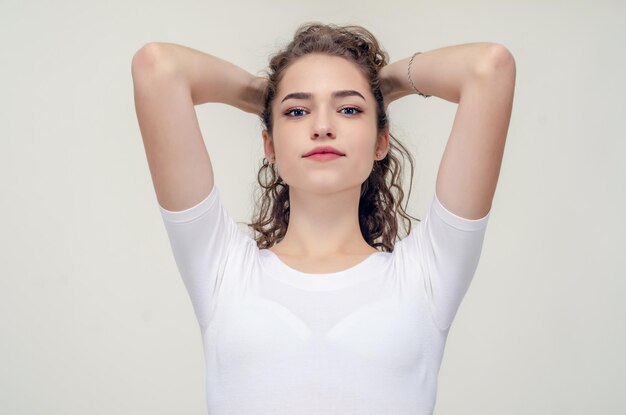 Young pretty girl gathered hair from behind elbows forward hands behind head