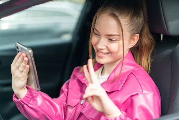 Young pretty girl inside a car using mobile phone