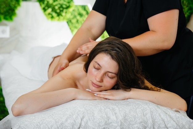 A young pretty girl is enjoying a professional cosmetological massage at the Spa. Body care. Beauty salon.