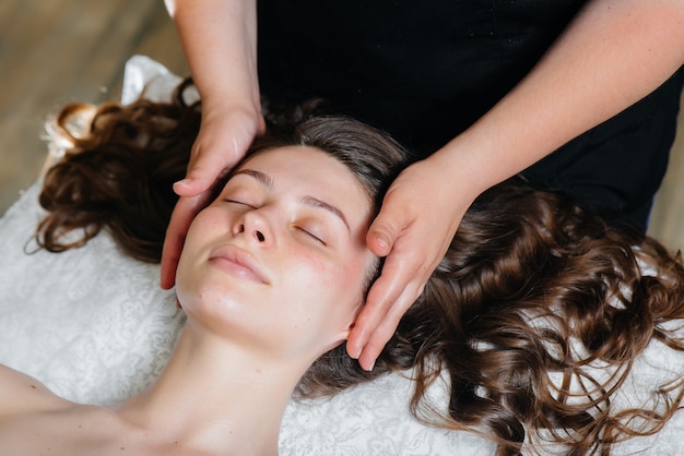 A young pretty girl is enjoying a professional head massage at the Spa.