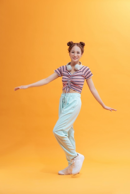 Young pretty girl jumping isolated on yellow background.