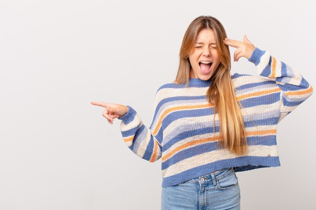 Young pretty girl looking unhappy and stressed, suicide gesture making gun sign