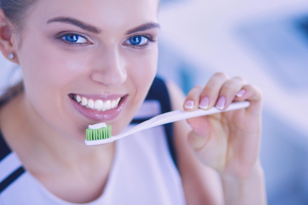 Photo young pretty girl maintaining oral hygiene with toothbrush