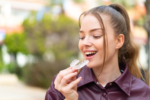 目に見えないブレースを保持している屋外で若いきれいな女の子