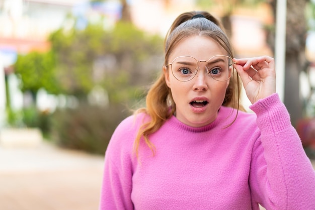 Young pretty girl at outdoors With glasses and frustrated expression