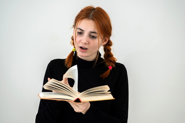 Young pretty girl read an open book in her hands. reading and education concept