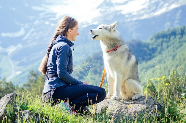 Young pretty girl running outdoor in the spring with Mountain dog