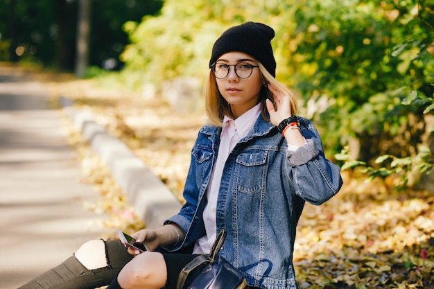 若い、かわいい女の子が夏の公園に座っている