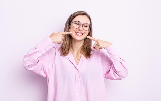 Young pretty girl smiling confidently pointing to own broad smile positive relaxed satisfied attitude