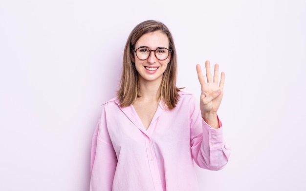 Giovane ragazza graziosa che sorride e che sembra amichevole che mostra il numero quattro o il quarto con il conto alla rovescia in avanti della mano