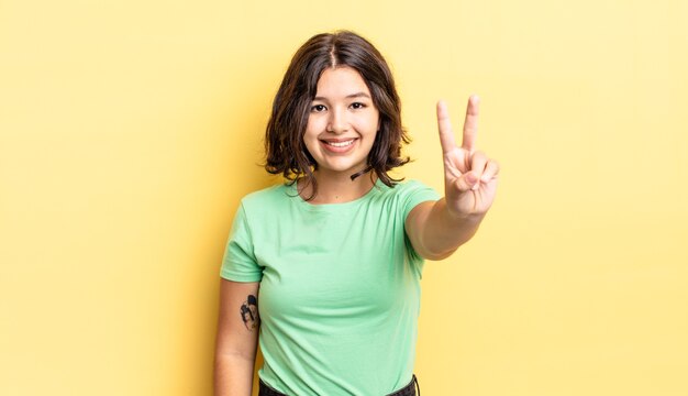 Young pretty girl smiling and looking friendly, showing number two or second with hand forward, counting down