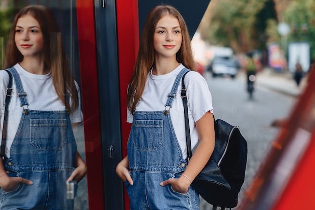 ブリーフケースを使って若いきれいな女の子街の反射を歩く