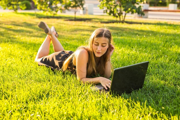 Young pretty girl with laptop working outdoor