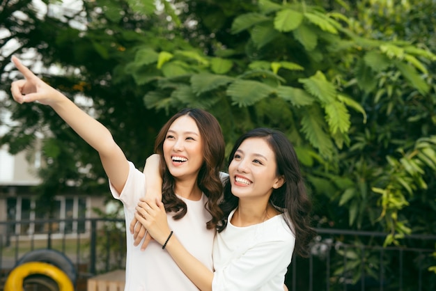 Young pretty girlfriends over nature background, in the garden