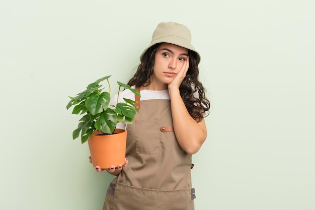 Молодая симпатичная латиноамериканка чувствует скуку, разочарование и сонливость после утомительной концепции фермера или садовника