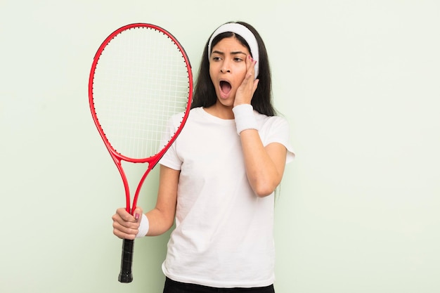 Young pretty hispanic woman feeling happy, excited and surprised. tennis concept