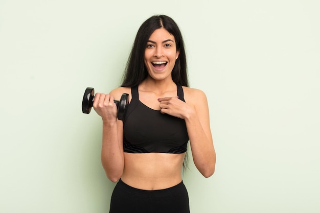 Young pretty hispanic woman feeling happy and pointing to self with an excited fitness concept