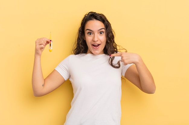 Young pretty hispanic woman feeling happy and pointing to self with an excited. thermometer concept