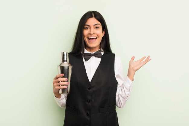 Young pretty hispanic woman feeling happy surprised realizing a solution or idea cocktail bartender concept