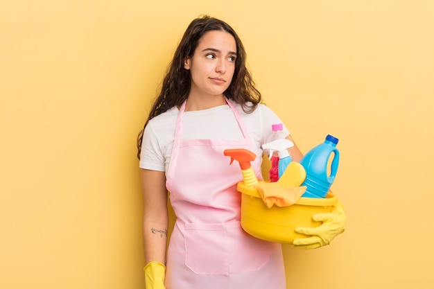 Young pretty hispanic woman feeling sad upset or angry and looking to the side housework an clean products concept