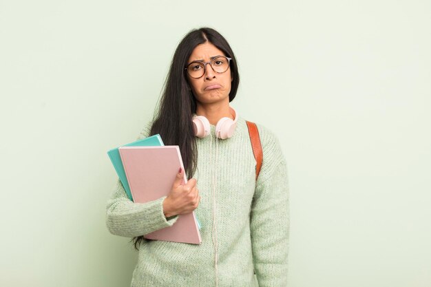 Giovane donna piuttosto ispanica che si sente triste e lamentosa con uno sguardo infelice e piangendo il concetto di studente