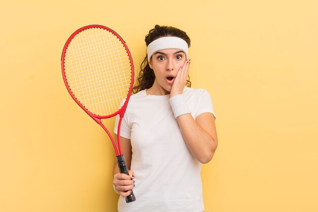 Young pretty hispanic woman feeling shocked and scared tennis concept