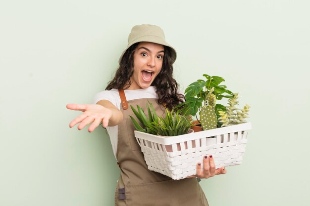 写真 若いかなりヒスパニック系の女性の庭師または植物と農家の概念