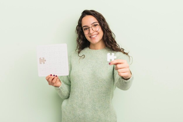 Young pretty hispanic woman holding a puzzle