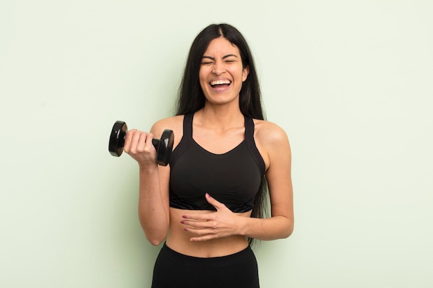 Photo young pretty hispanic woman laughing out loud at some hilarious joke fitness concept