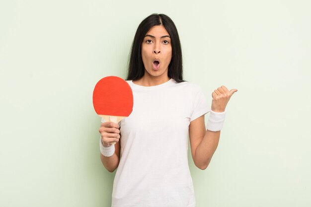 Giovane donna abbastanza ispanica che sembra stupita nel concetto di ping pong incredulo