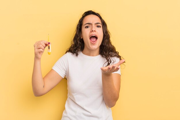 Young pretty hispanic woman looking desperate frustrated and stressed thermometer concept