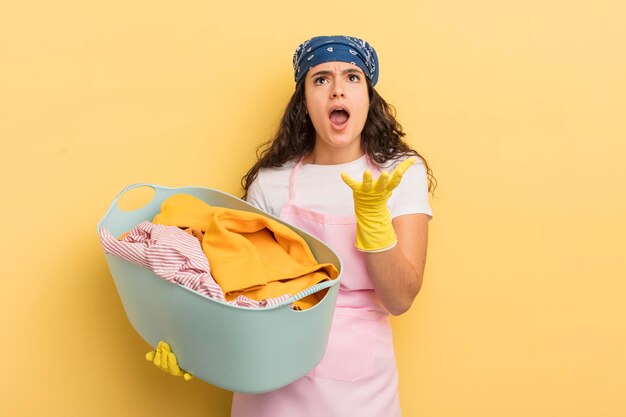 Young pretty hispanic woman looking desperate, frustrated and stressed. wash and clothes concept