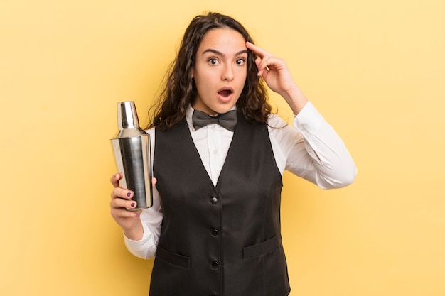 Young pretty hispanic woman looking surprised realizing a new thought idea or concept bartender and cocktail concept