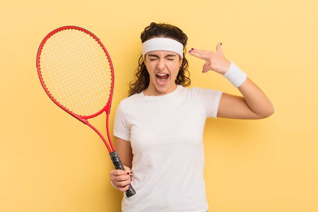 Young pretty hispanic woman looking unhappy and stressed suicide gesture making gun sign tennis concept
