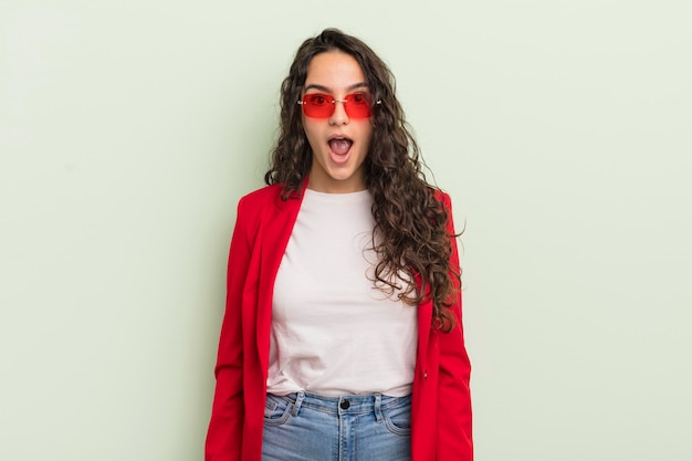 young pretty hispanic woman looking very shocked or surprised. cool businesswoman